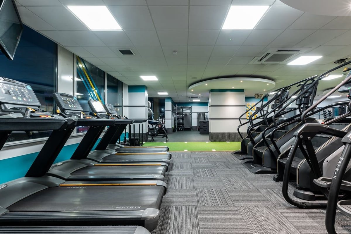 PureGym London Edgware: Rows of treadmills, rowing machines, and cable cross trainers in a brightly lit fitness studio.