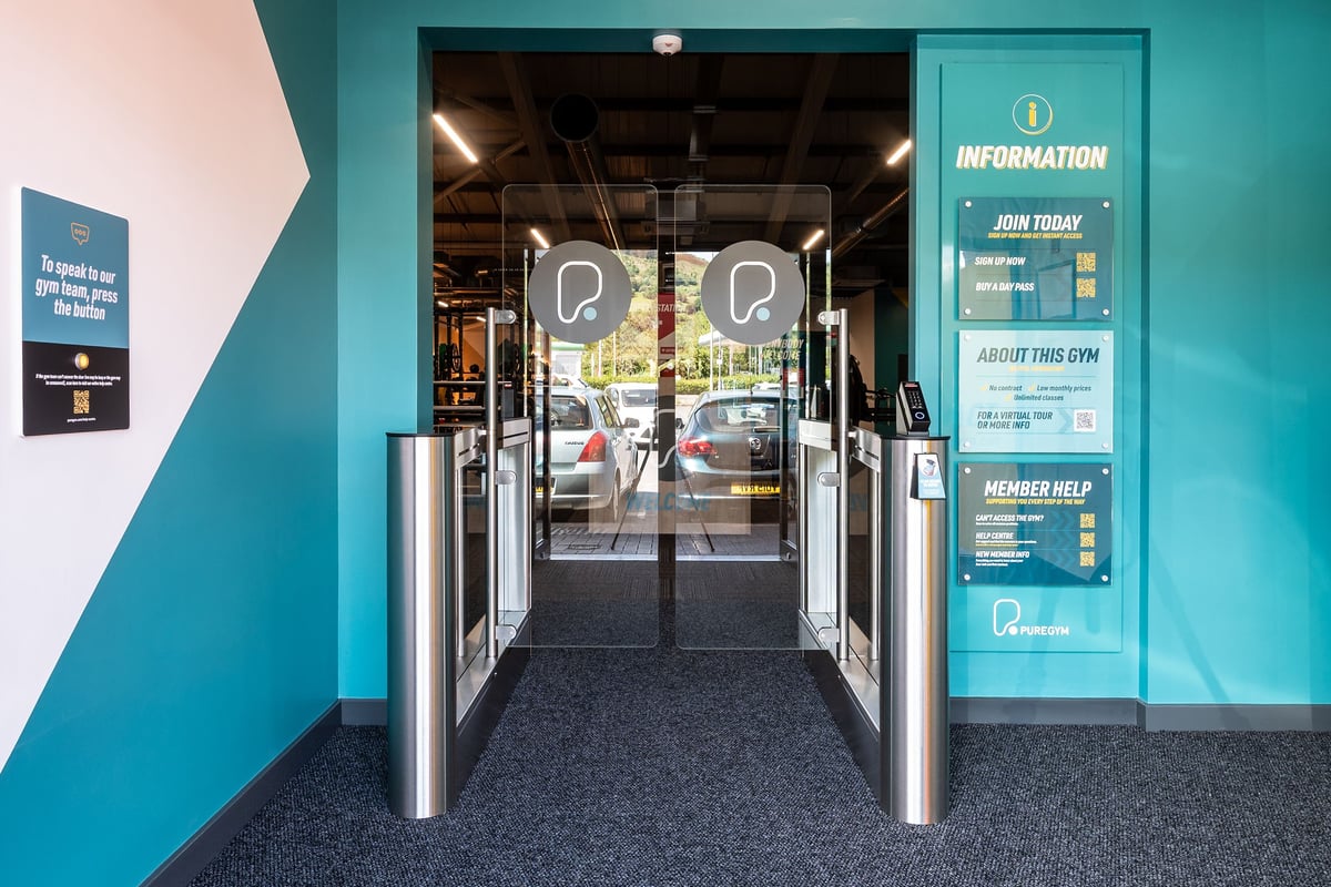PureGym Aberdare: Entrance area with turnstiles, information desk, and floor signage.