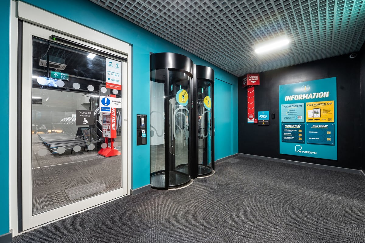 PureGym Norwich Castle Mall: Beverage vending machines, information kiosk, carpeted floor space.
