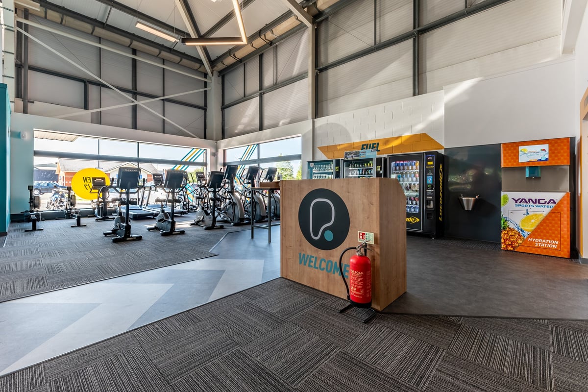 PureGym Crewe Grand Junction Retail Park: Rows of cardio machines, vending machines, cubbies, and patterned rubber flooring.