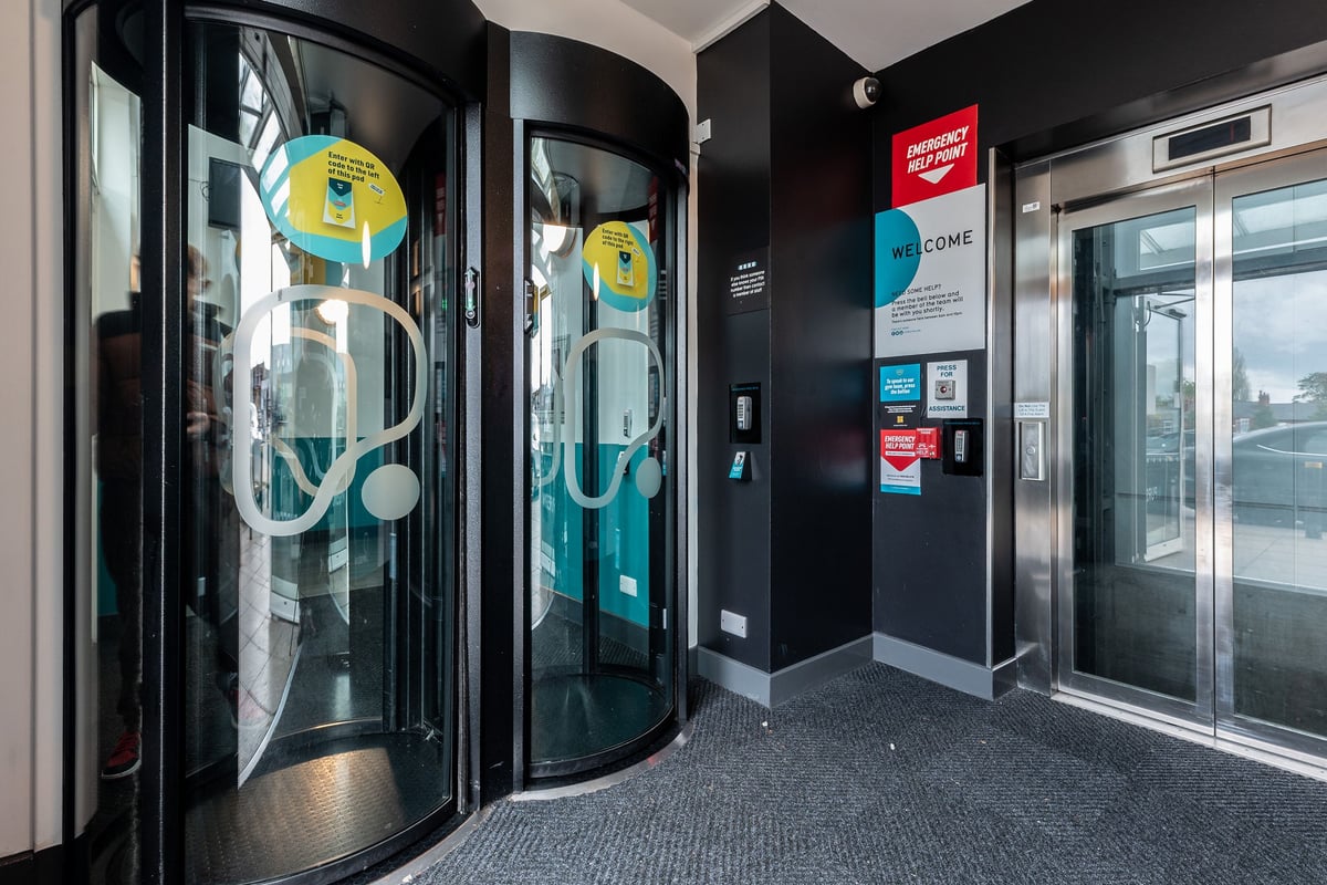 PureGym Birmingham West: Revolving doors with teal and yellow coloured exercise machines visible inside.