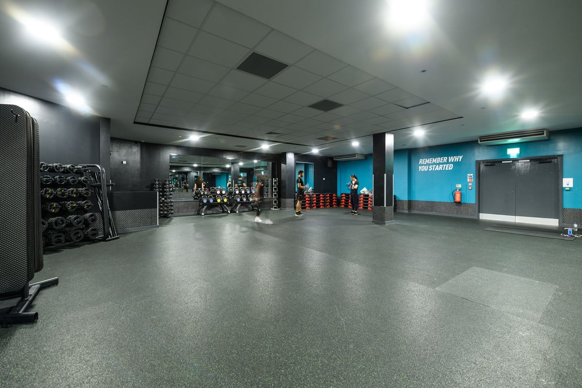 PureGym Northampton Central: Strength machines, free weights, mirrors along walls, and rubberized flooring in a modern gym.