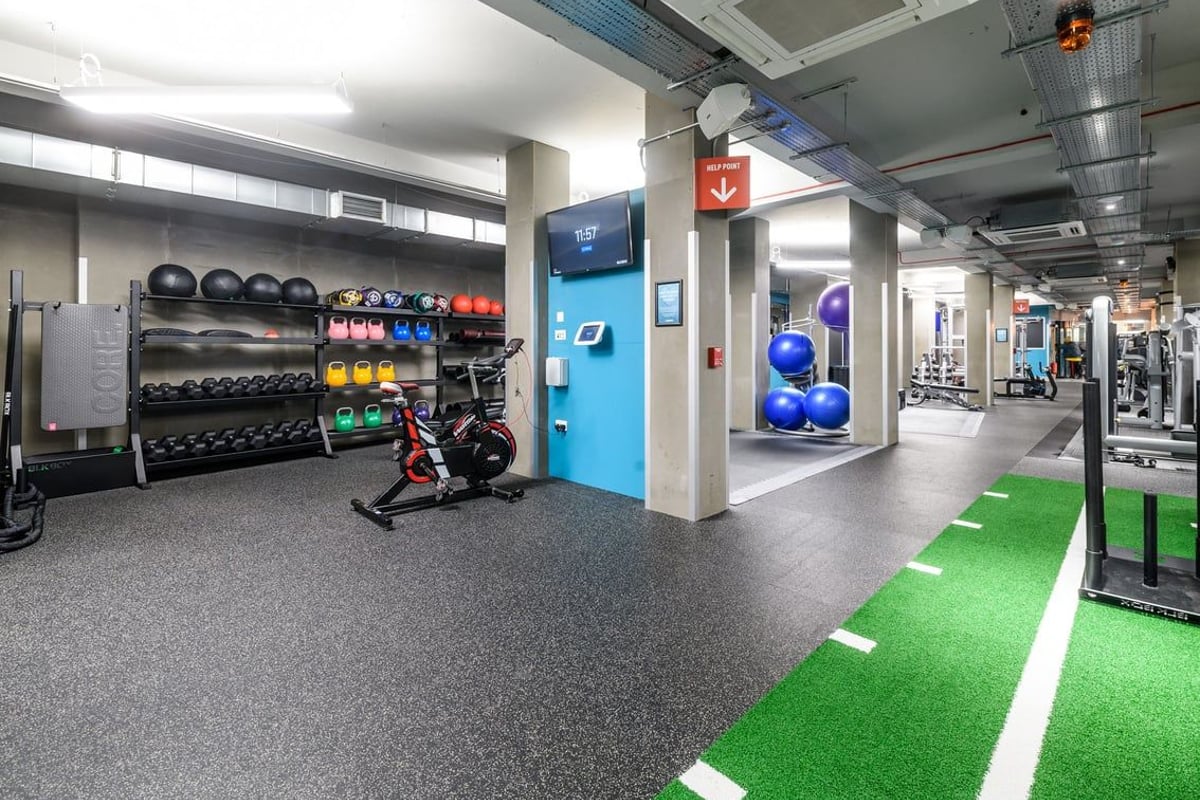 PureGym London Lewisham: Free weight racks, medicine balls, turf area, resistance machines, rubberized flooring.