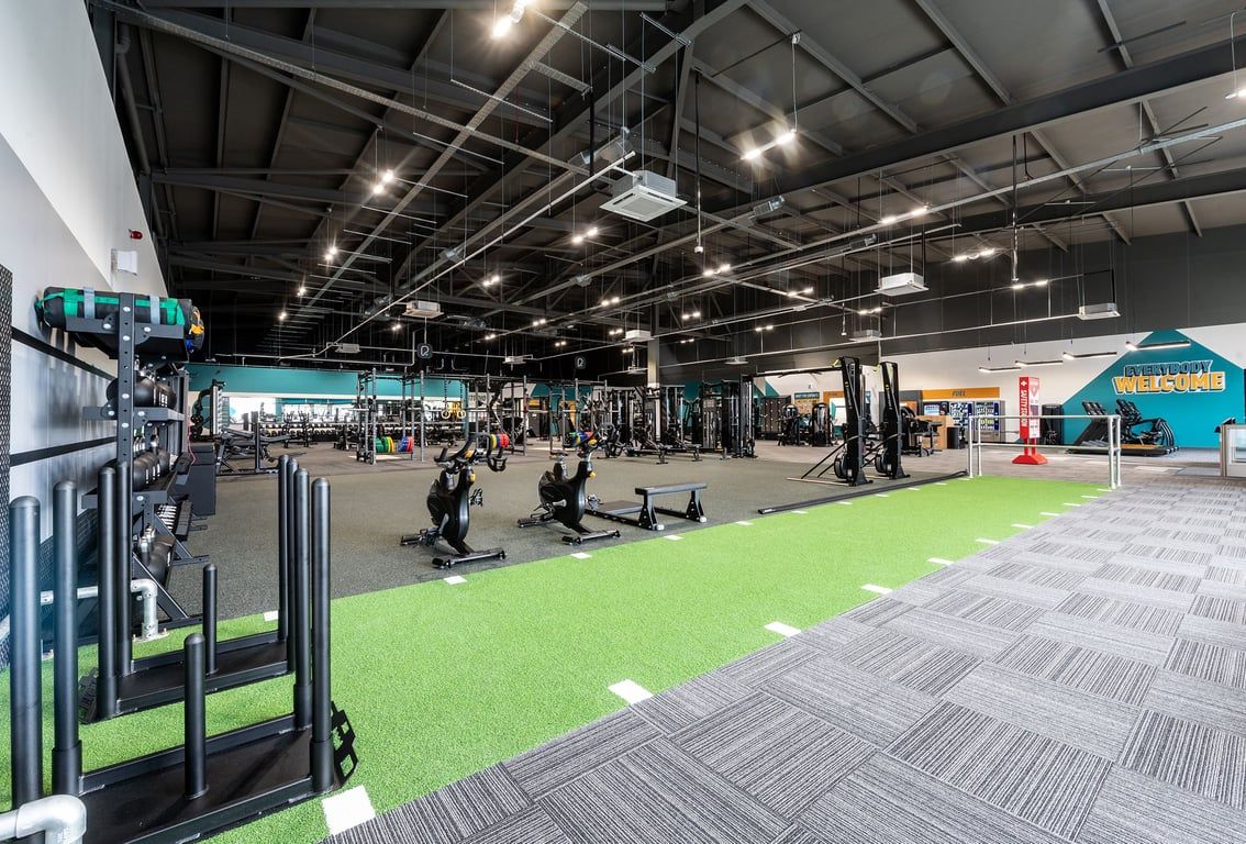 PureGym Walsall Crown Wharf: Functional training area with green turf, weight racks, free weights, and exercise machines.