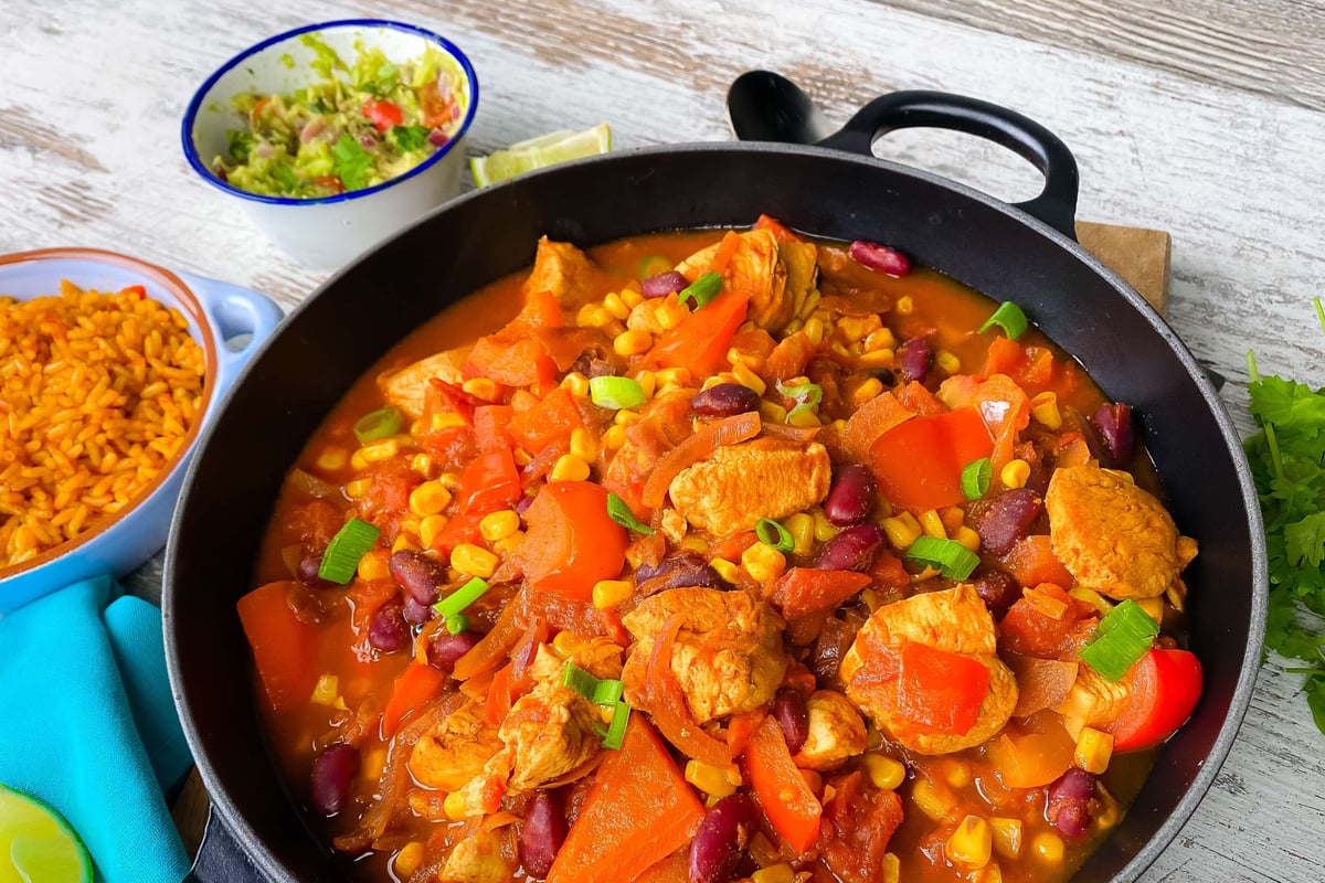 One pot chicken stew with peppers, beans and sweetcorn served with rice and salad