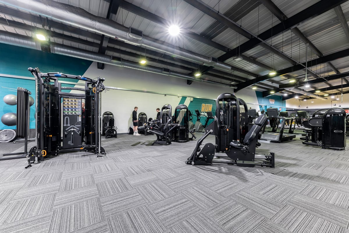 PureGym Lincoln St Marks Centre: Resistance machines, weight racks, free weights, rubberized flooring in a well-lit gym.