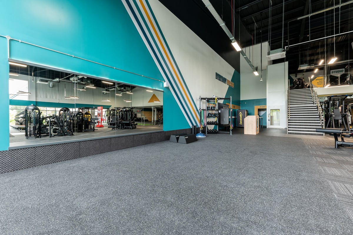 PureGym Doncaster: Rows of resistance machines, free weights, benches, and rubberized flooring in a vibrant gym setting.