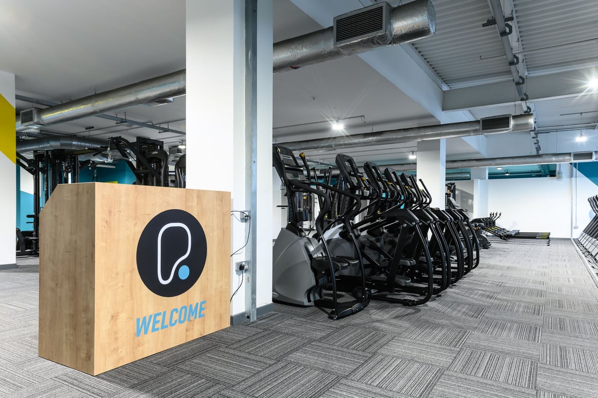 PureGym East Kilbride: reception hub in a gym with cardio machines in the background