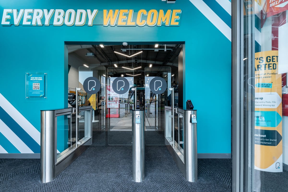 PureGym Liverpool Edge Lane: Entrance area with turnstiles and 'everybody welcome' signage.
