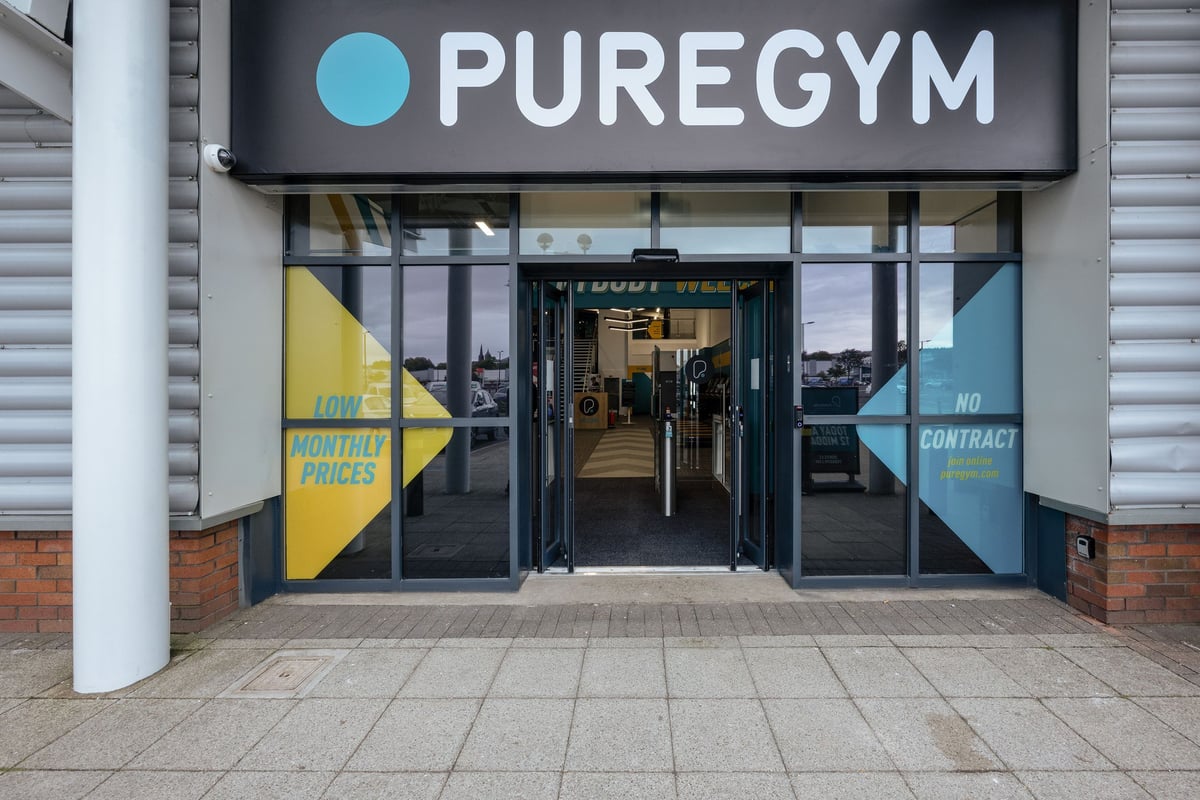 PureGym Falkirk: Pure Gym storefront, with entrance leading inside and advertisement banners visible.