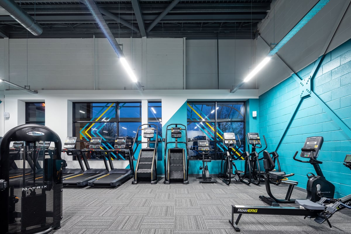 PureGym Wantage: Rows of cardio machines, strength equipment, and mirrored walls in a modern gym interior.