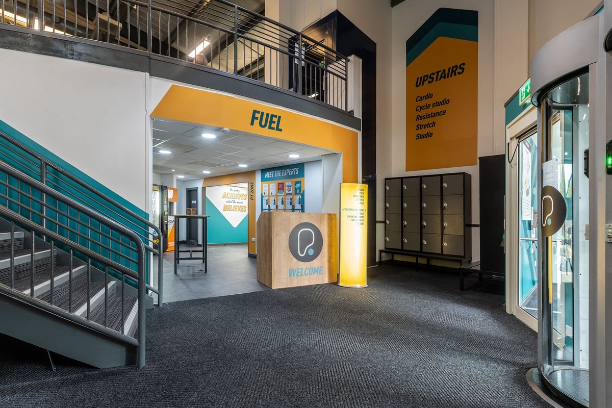 PureGym Aintree: No fitness equipment shown; looks like a building lobby with lockers, signage for "FUEL" and "UPSTAIRS".