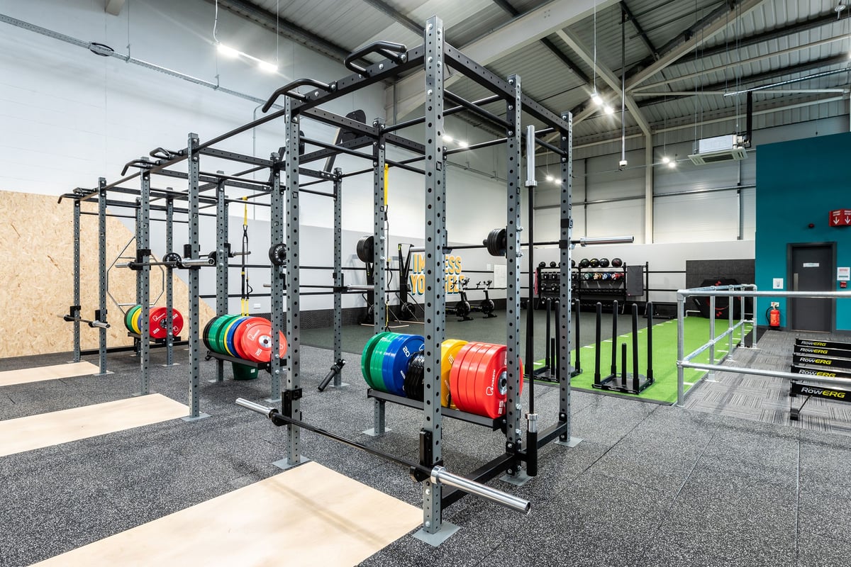 PureGym Newbury: Squat racks, weight plates in multiple colours, rubberized flooring, and heavy-duty equipment racks.