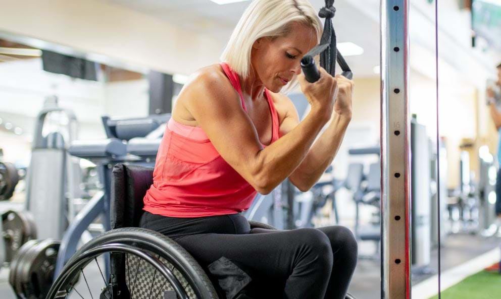 Person using gym equipment, illustrating disability-friendly access.