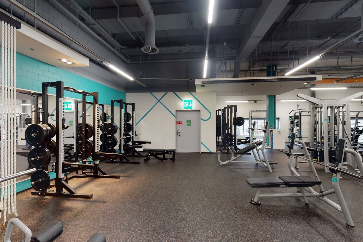 PureGym Winterthur Töss: Salle de sport avec haltères, bancs, sols caoutchoutés et miroirs.