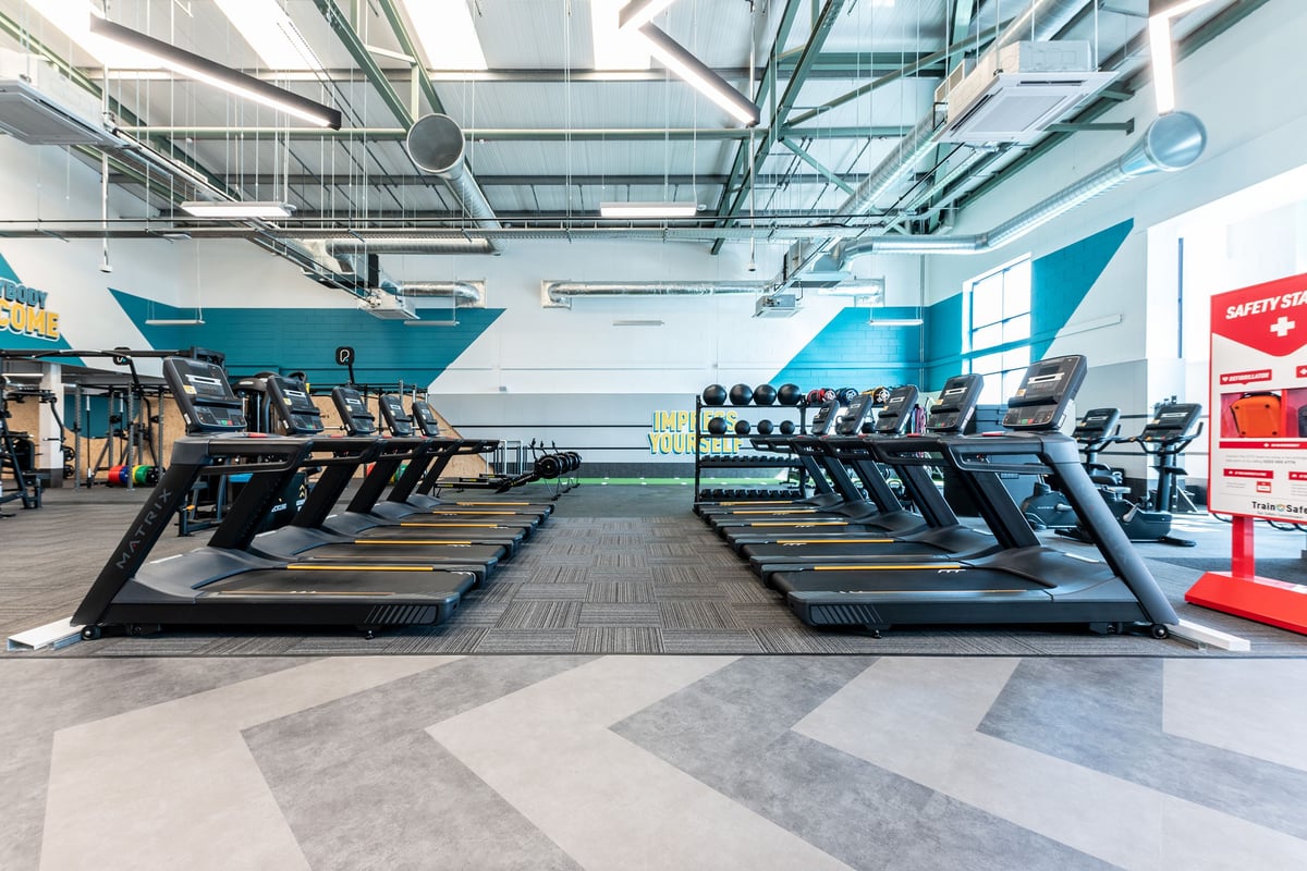 PureGym Coleraine: Rows of treadmills, static bikes, and elliptical machines in a brightly lit gym facility.
