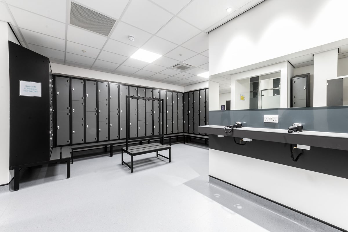 PureGym Bracknell: Locker room with benches, individual lockers, and a counter area.