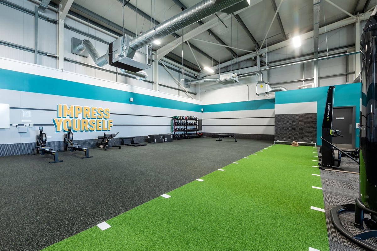 PureGym Stamford: Turf area with weightlifting platforms, free weights, punching bags, and exercise equipment.