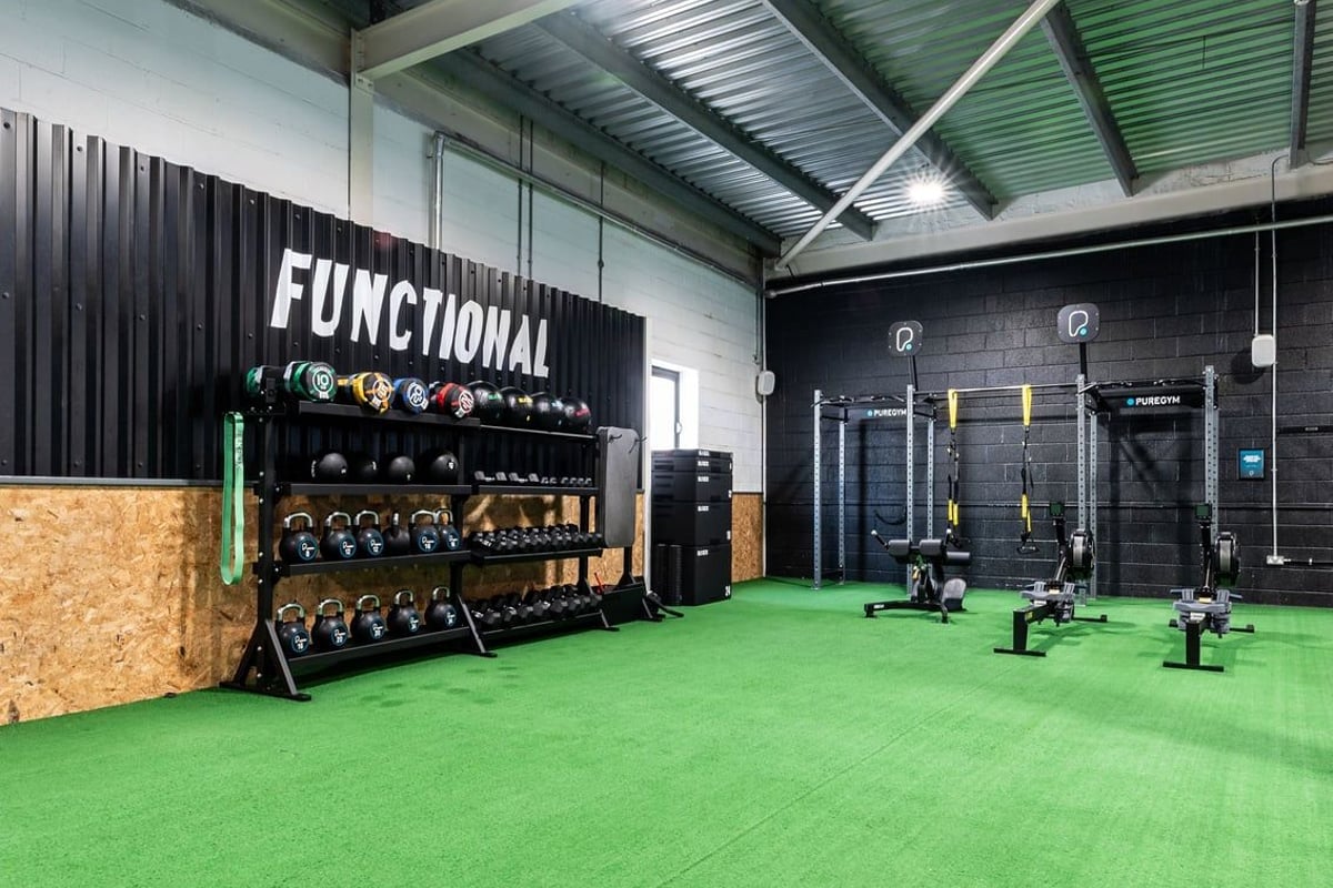 PureGym Bristol Union Gate: Functional training area with weight racks, kettlebells, squat racks, green turf flooring.