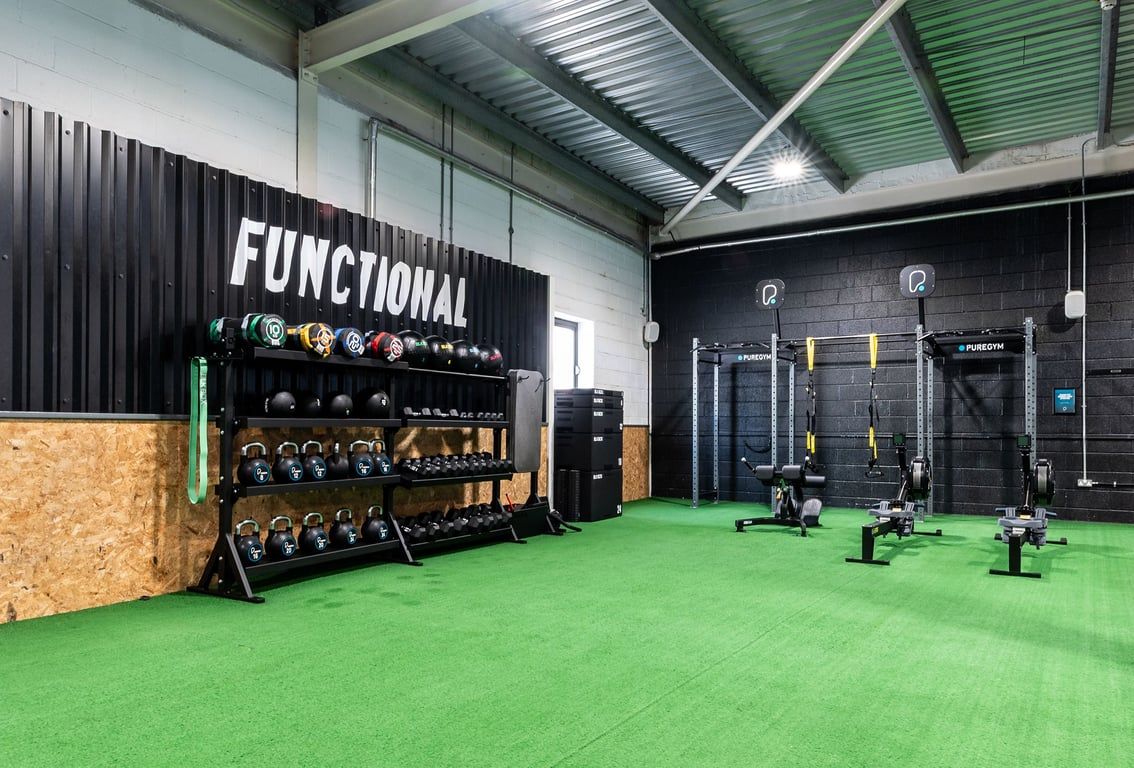 PureGym Bristol Union Gate: Functional training area with weight racks, kettlebells, squat racks, green turf flooring.