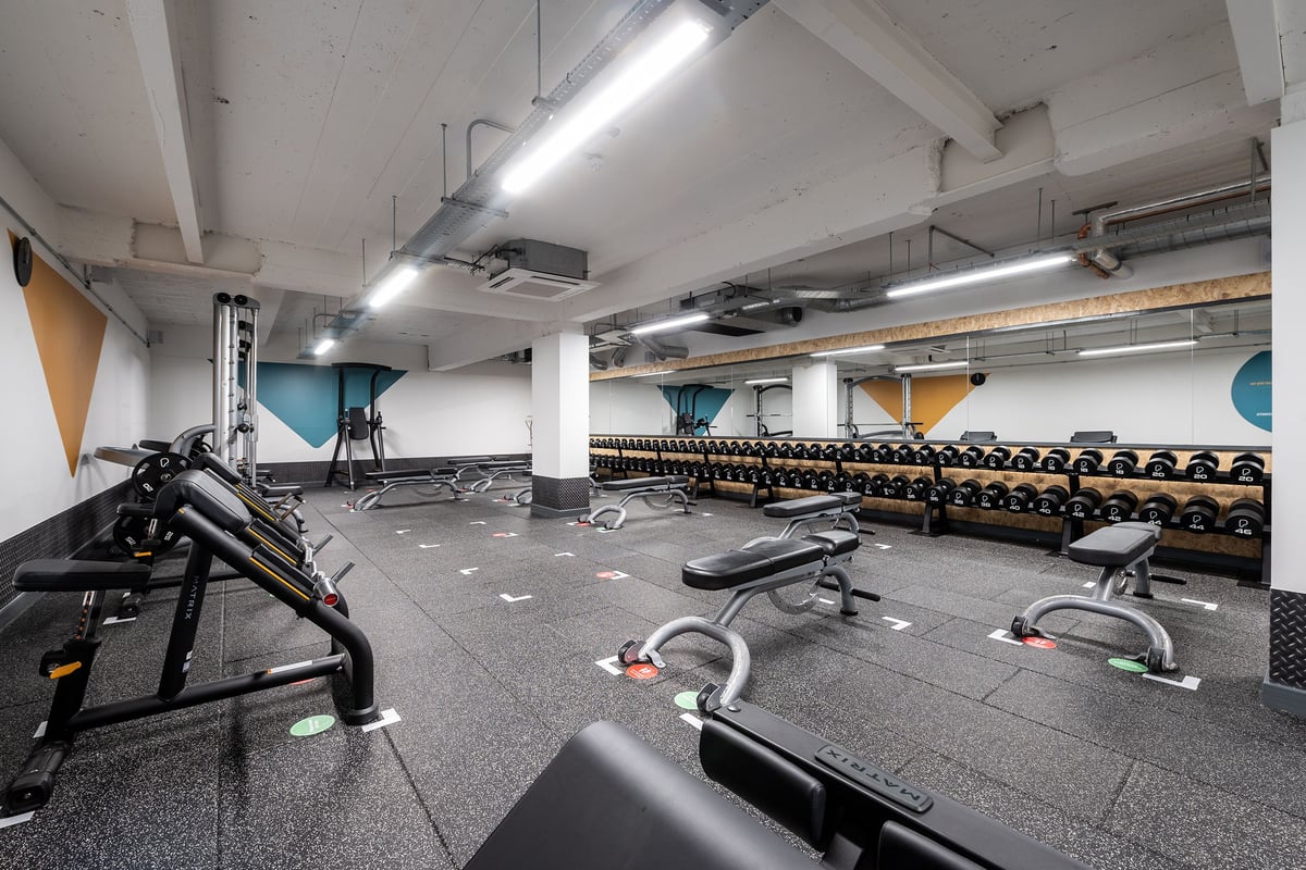 PureGym London Holloway Road: Weightlifting area with benches, free weights, resistance machines, and rubberized flooring.