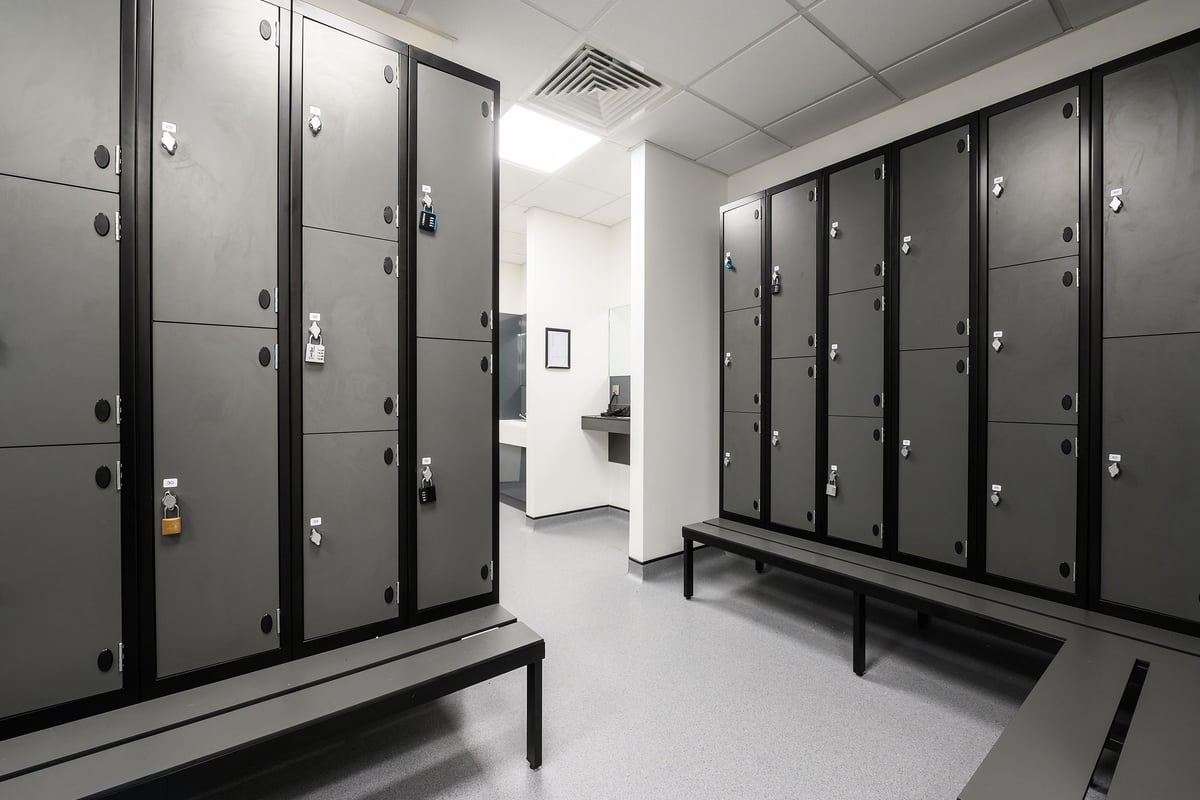 PureGym Bromsgrove Retail Park: Rows of lockers, benches in grey and black hues - a changing room interior.