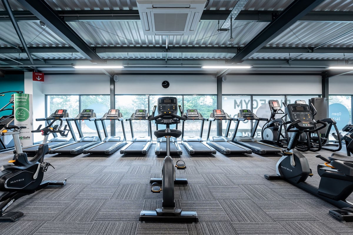 PureGym Kirkcaldy: Rows of treadmills, ellipticals, and exercise bikes in a gym cardio area.