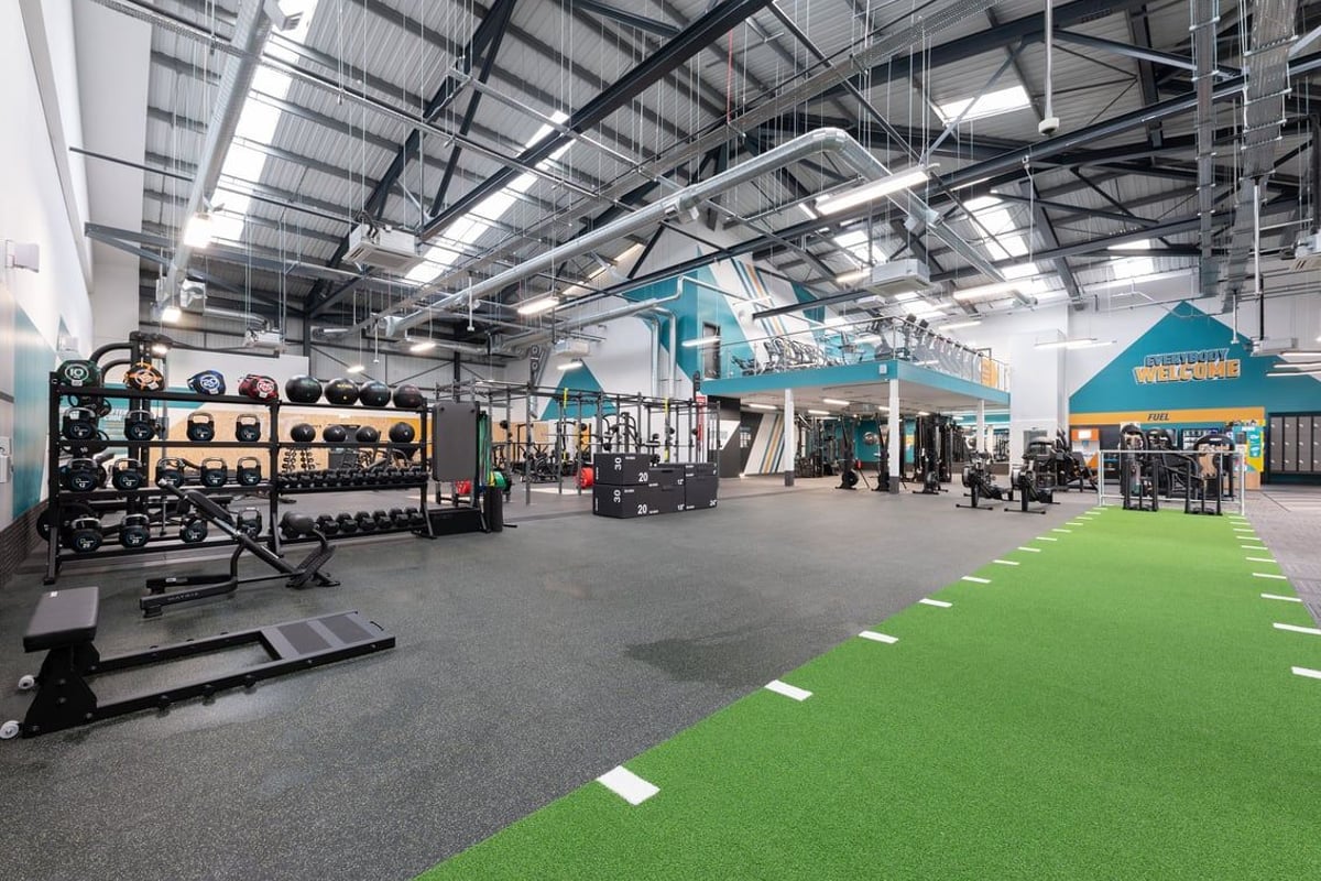 PureGym Southport: Resistance machines, free weight racks, turf area, rubberized floors, exposed ceiling structure.