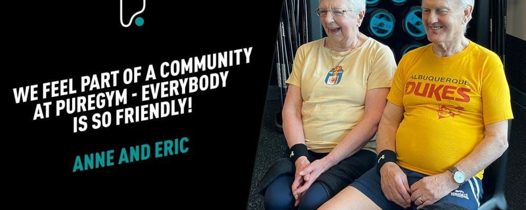 Two elderly people sitting and smiling in a gym with weights in the background