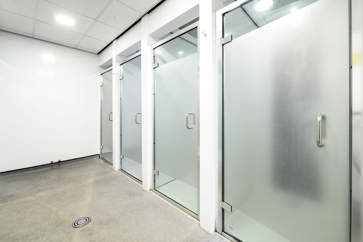 PureGym London Greenwich: Frosted glass doors leading to changing rooms or shower facilities.
