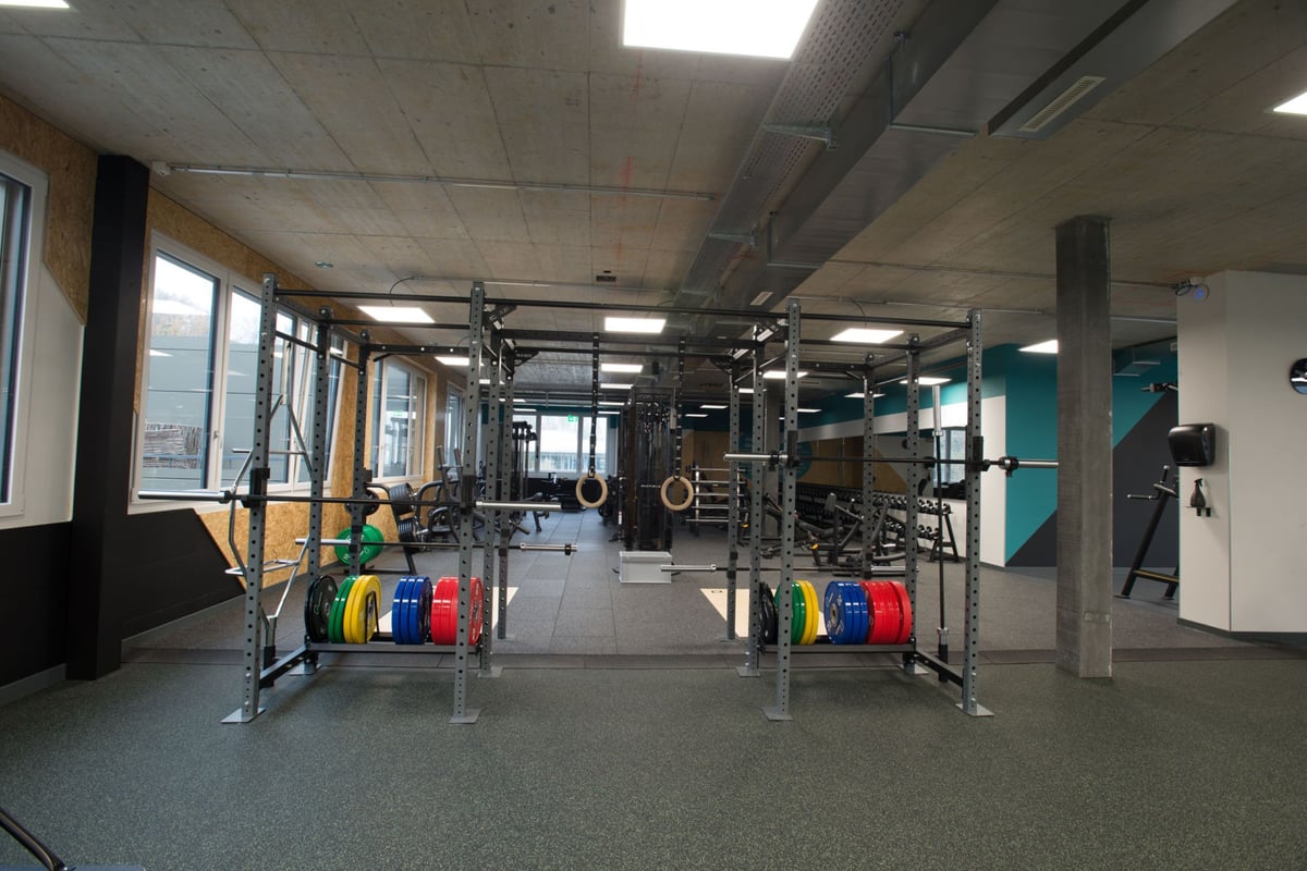 PureGym Adliswil: Supports de musculation, appareils de résistance, sol caoutchouté et miroirs muraux.