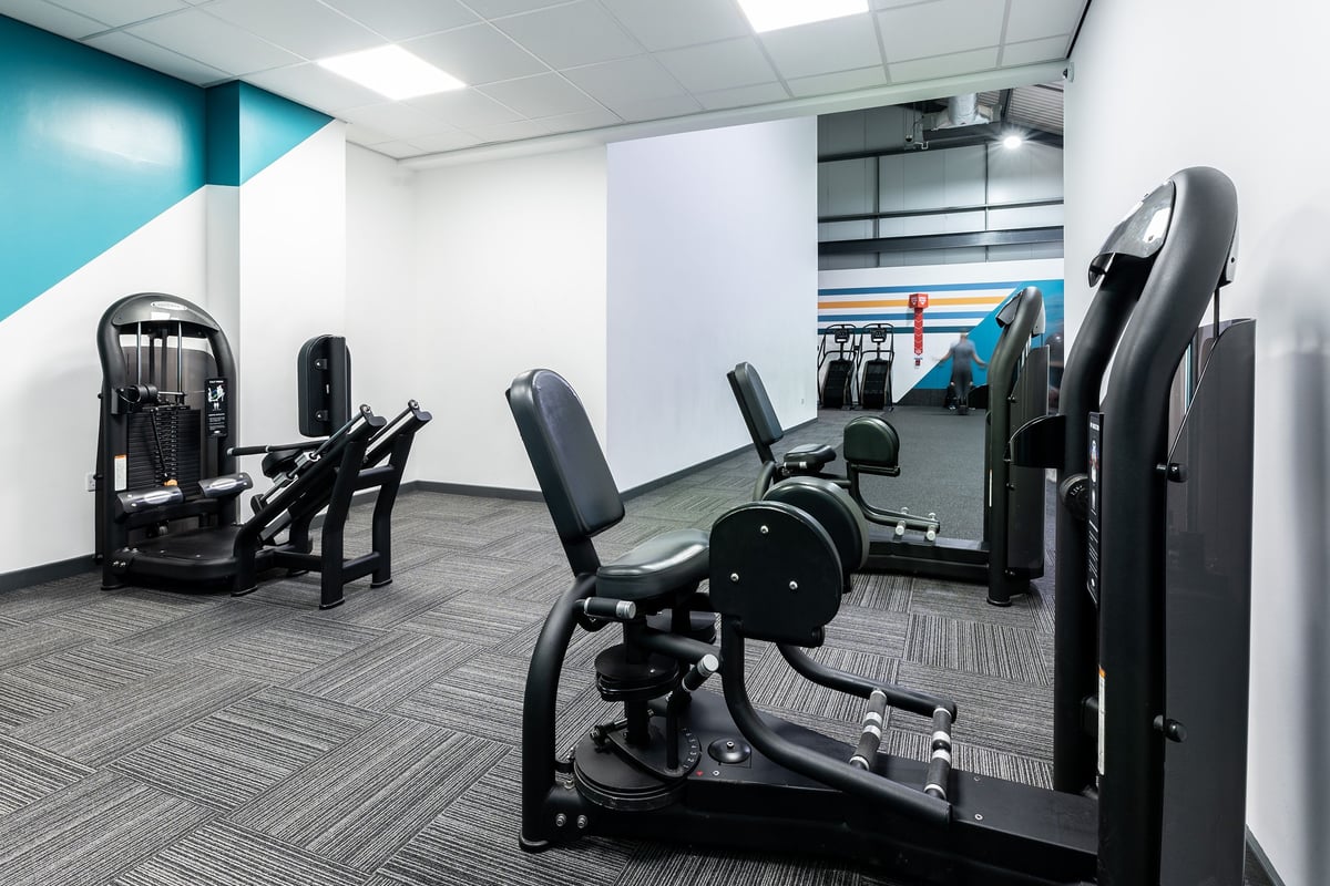 PureGym Chatham: Resistance machines, weighted benches, and mats in a gym studio with blue accent walls.