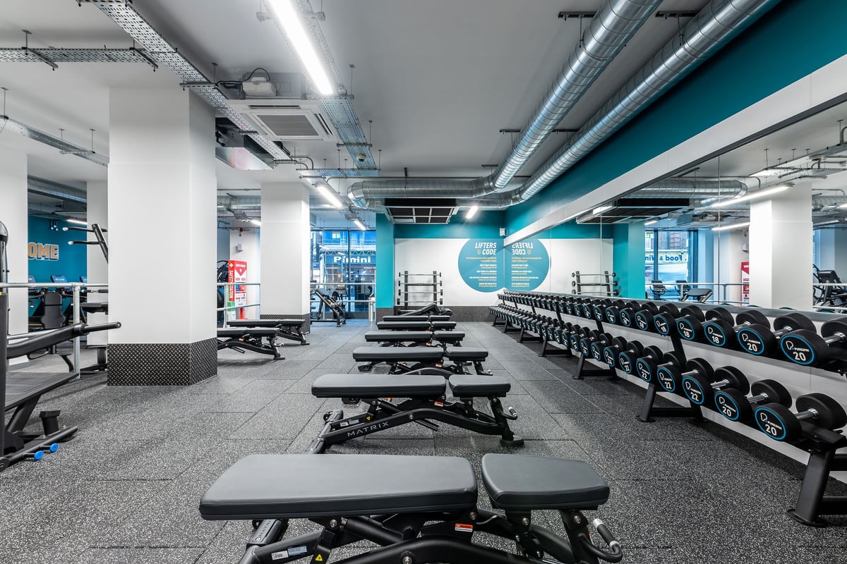 PureGym London Palmers Green: Rows of weight benches, dumbbell racks, lifting platforms, and rubberized flooring.