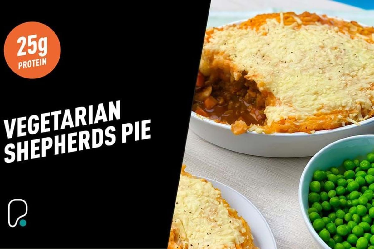 Vegetarian shepherds pie with melted cheese topping and a bowl of green peas.