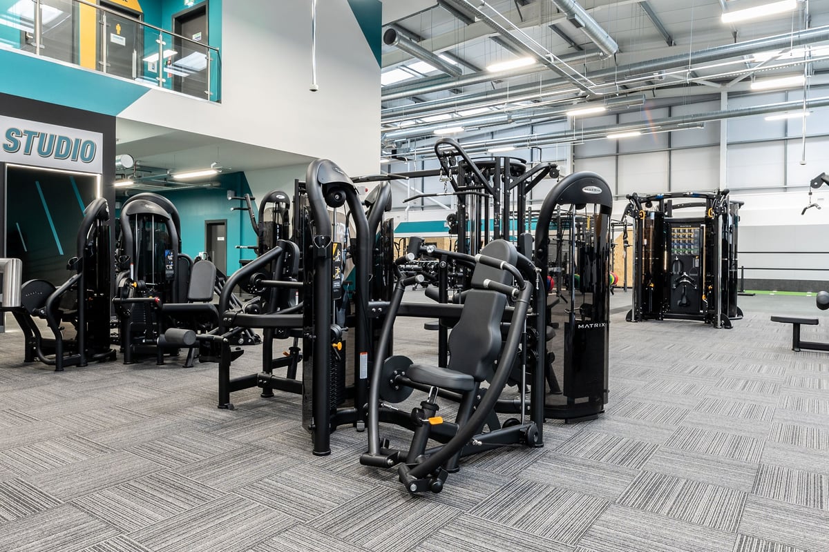 PureGym Blyth: Resistance machines, free weights, benches, and rubberized flooring inside a gym studio.