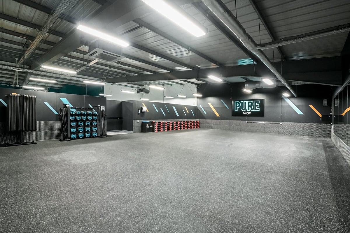 PureGym Canterbury Sturry Road: Weight racks, punching bags, padded floors in an industrial-style training area.