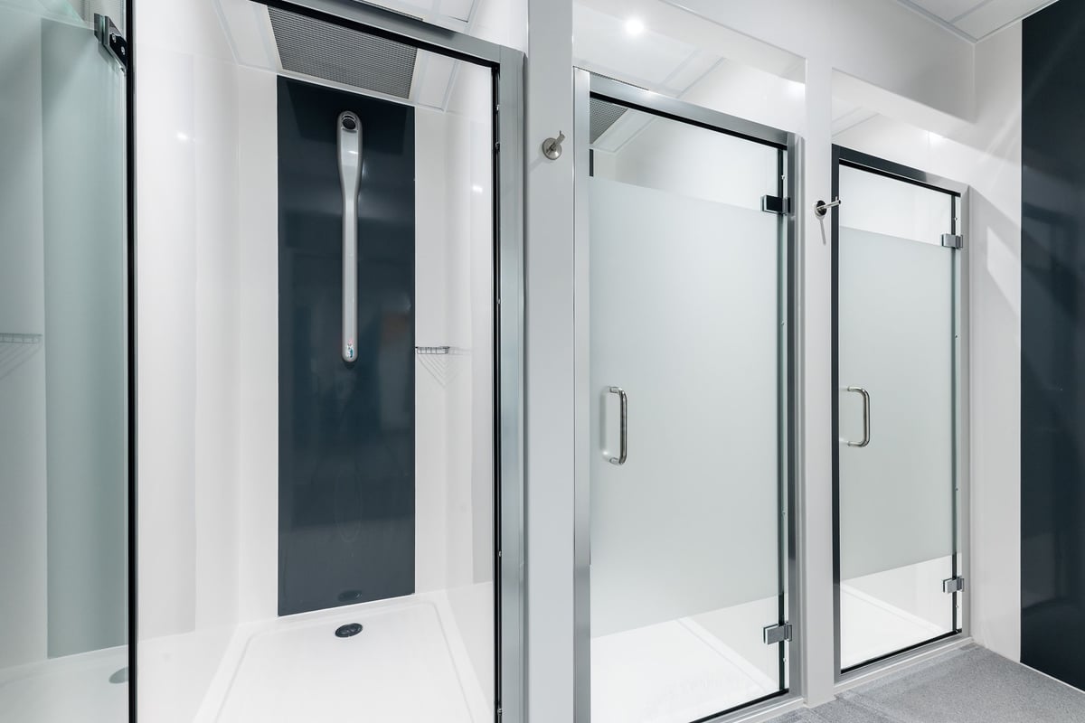 PureGym Crewe Grand Junction Retail Park: Shower cubicles with frosted glass doors and tiled walls.