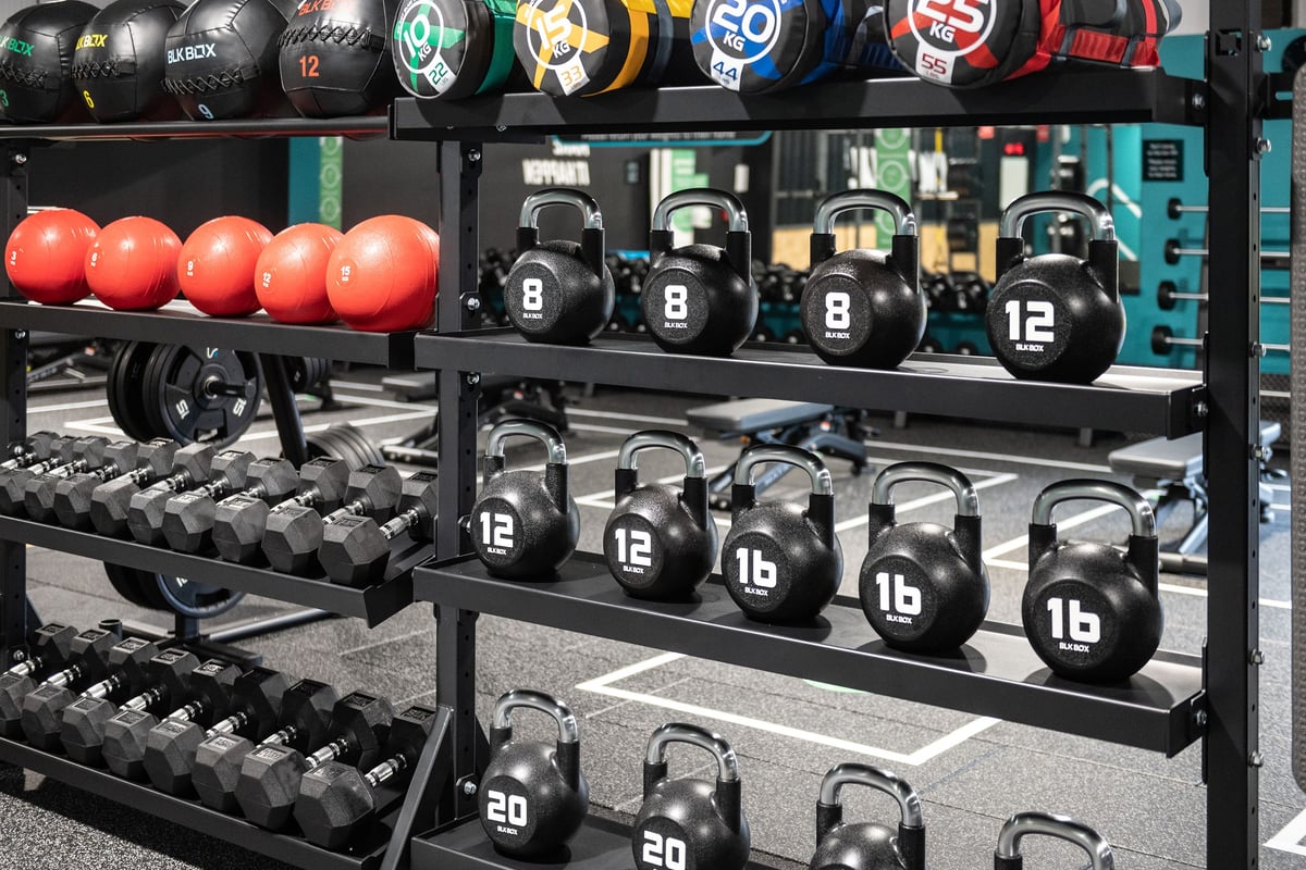 PureGym Kirkcaldy: Rows of kettlebells, medicine balls, and weight plates neatly organised on racks.