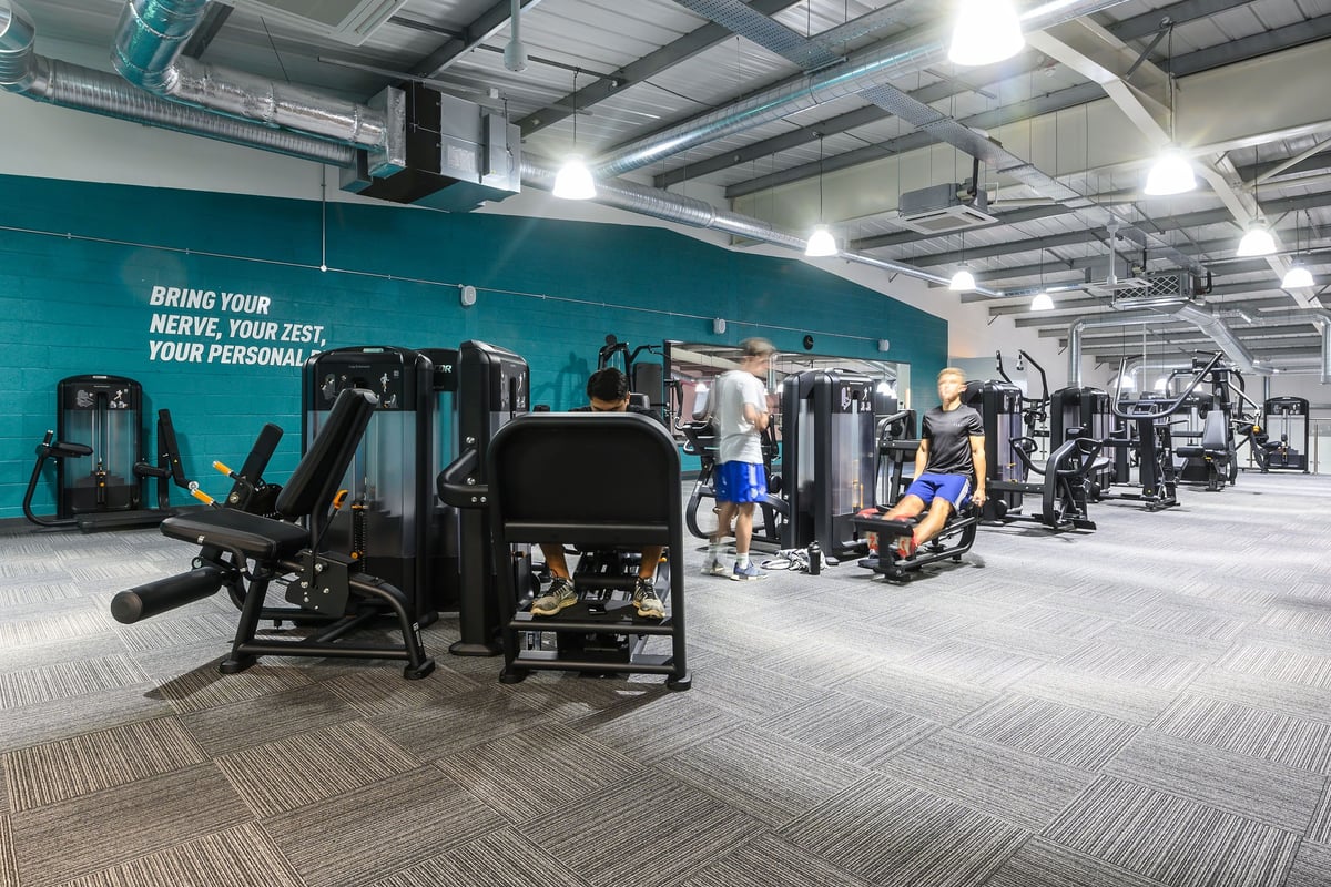 PureGym Bristol Abbey Wood Retail Park: Resistance equipment and motivational teal wall graphic in a gym setting.