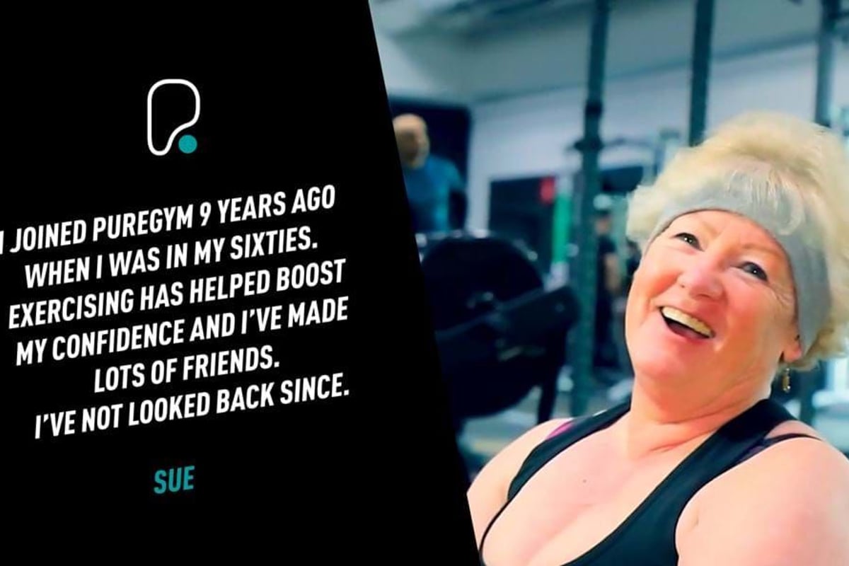 Smiling elderly woman wearing a headband and gym clothes in a fitness centre.