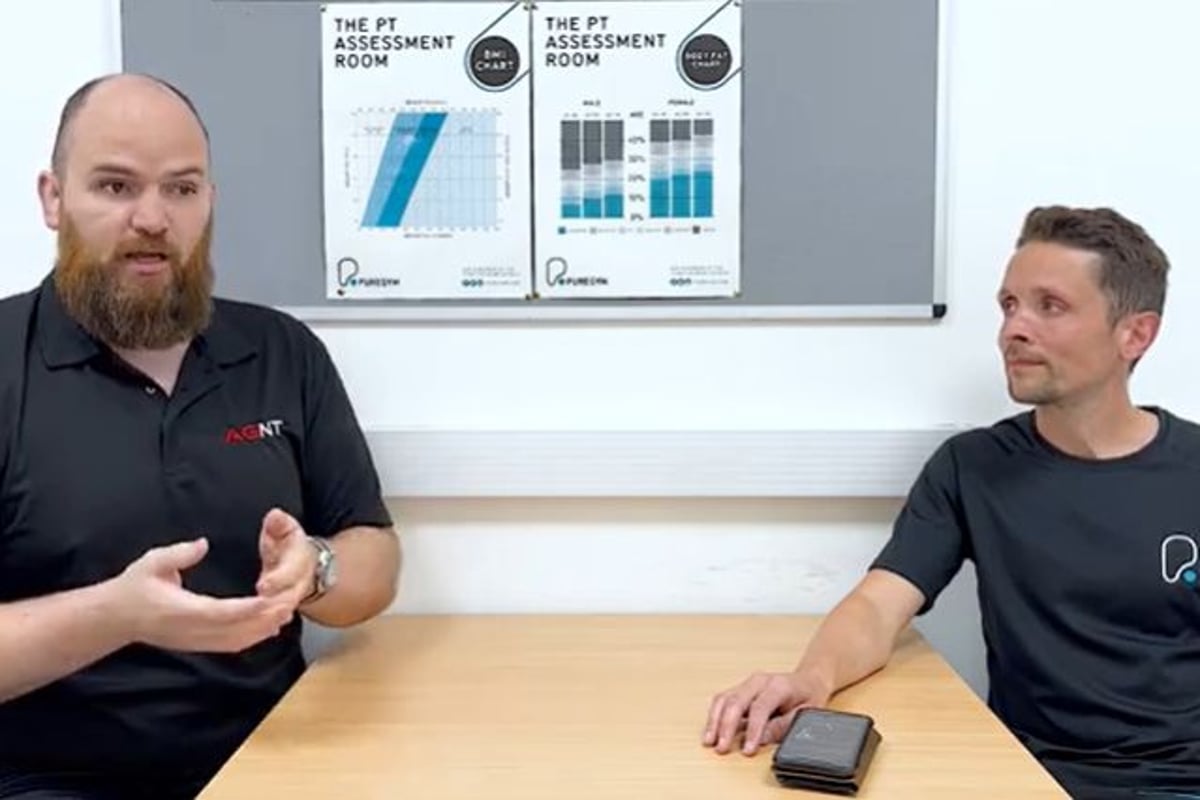 Two personal trainers sitting at a table doing a Q&A