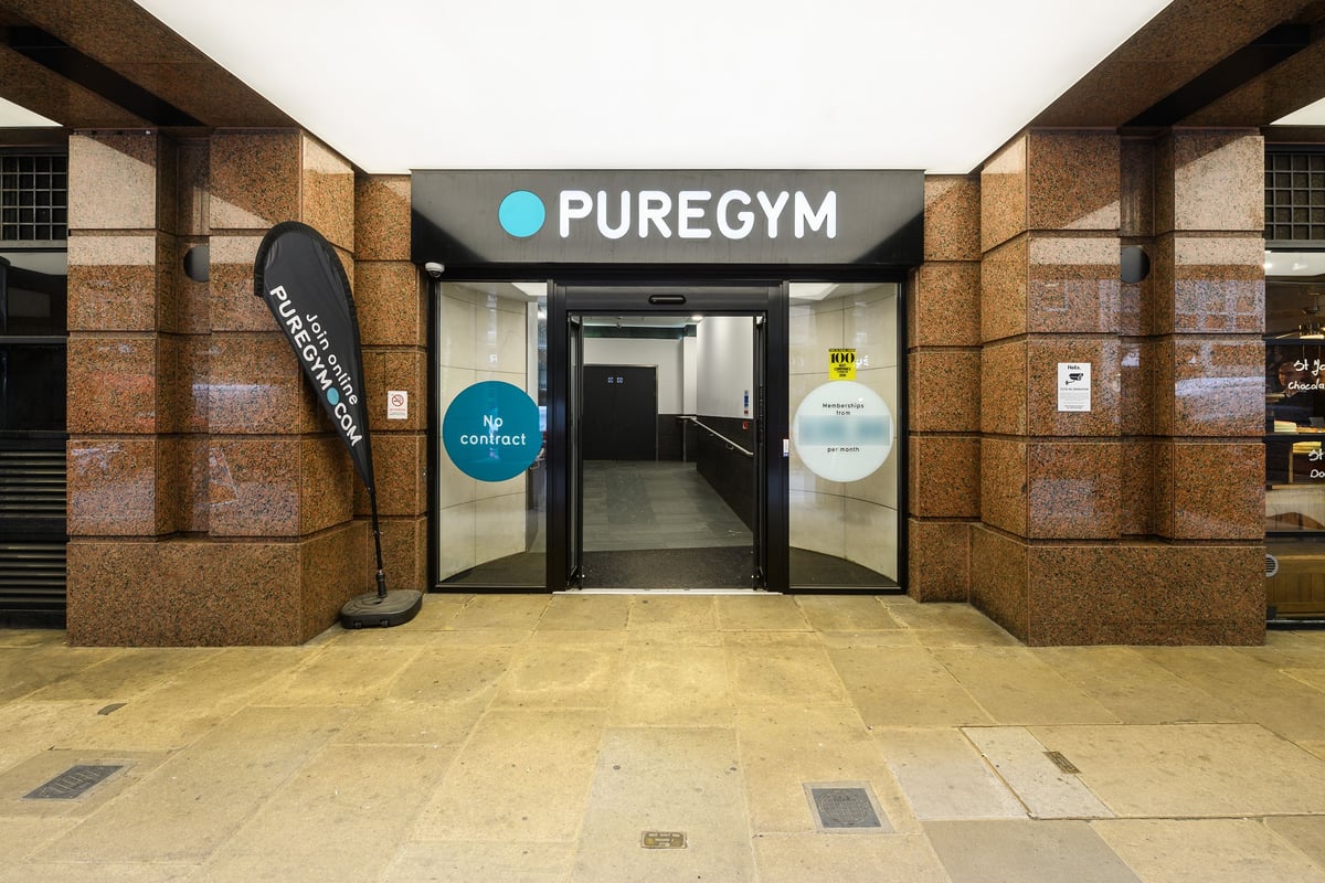 PureGym London Moorgate: Gym entrance with signage, umbrella stand and glass doors leading inside.