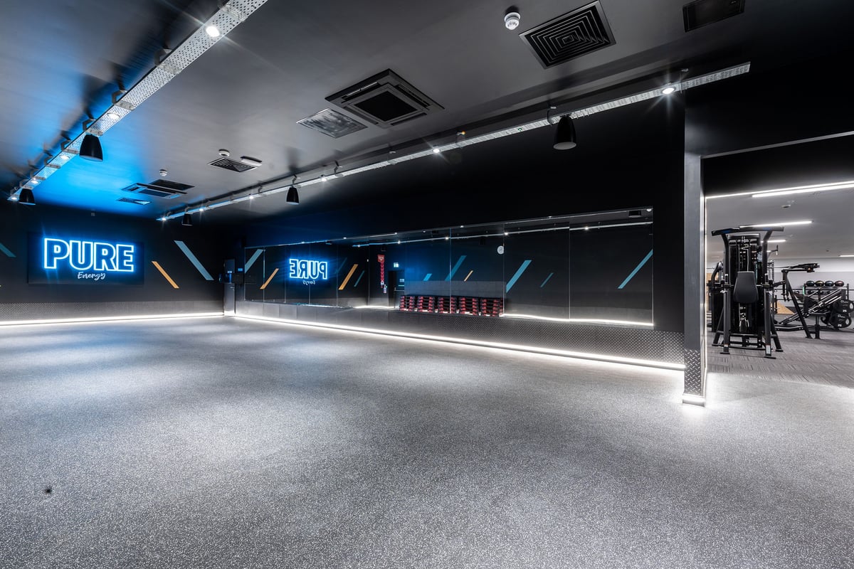PureGym Knaesborough: Bright studio interior, weight plates lined up, weight training area with benches.