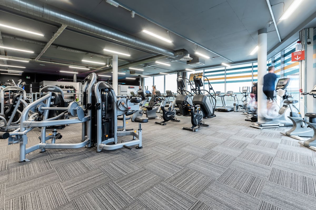 PureGym Walton-on-thames: Resistance machines, exercise bikes, and free weights arranged in a brightly lit gym interior.