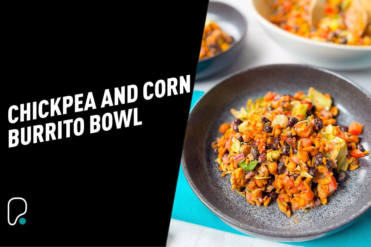 Chickpea and corn burrito bowl with black beans, rice, and vegetables in a grey bowl