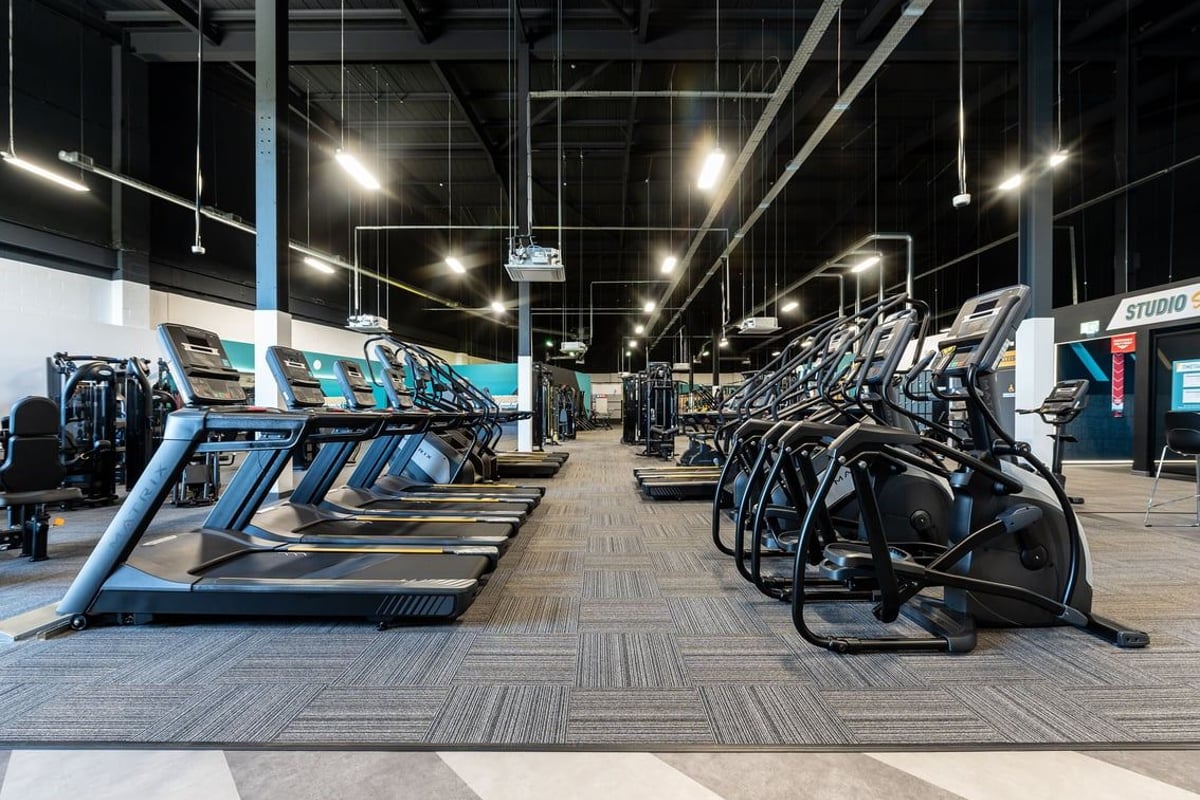 PureGym Stockton-on-tees Teesside Park: Rows of treadmills and exercise bikes in a brightly lit gymnasium studio interior.