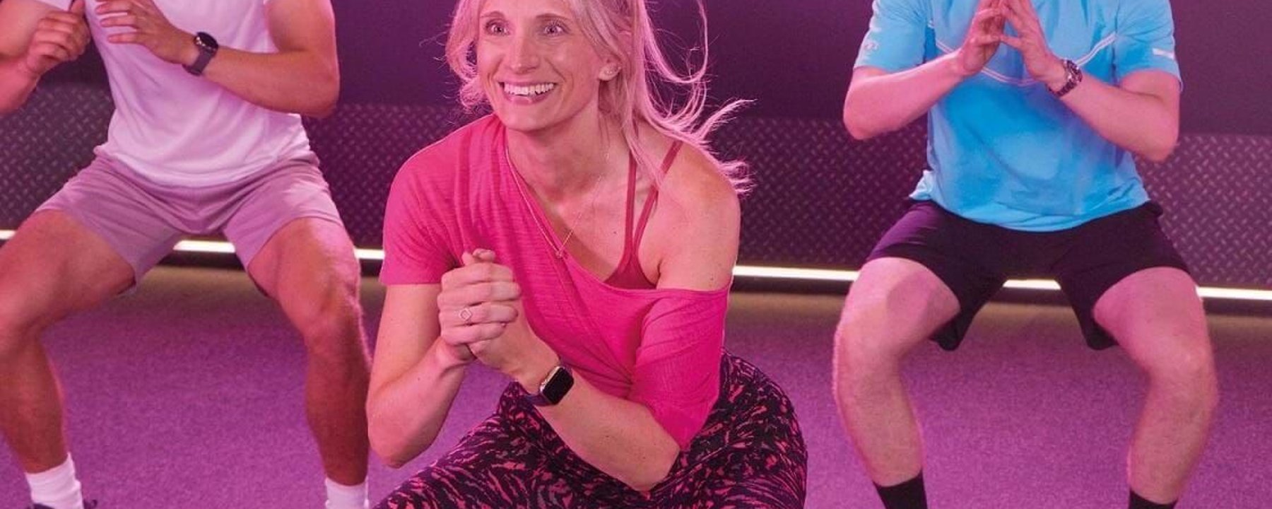 PureGym: a female member in sports gear participating in a no-equipment fitness class