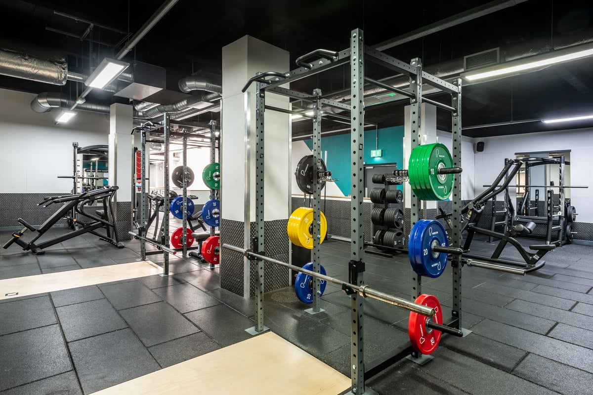 PureGym Manchester Market Street: Squat racks, weight plates in varied colours, and other weightlifting equipment.