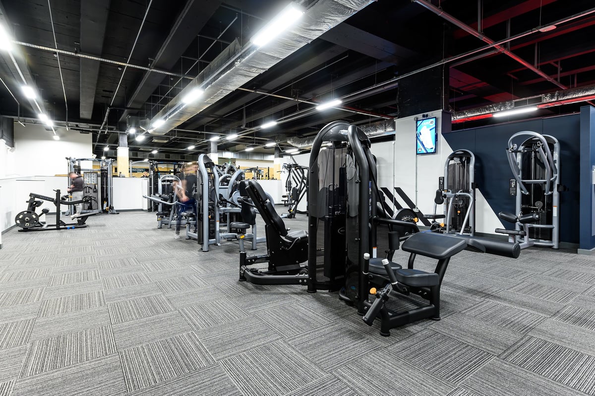PureGym Leeds City Centre North: Commercial gym setup with weight machines, free weights, mirrors, and rubberised flooring.