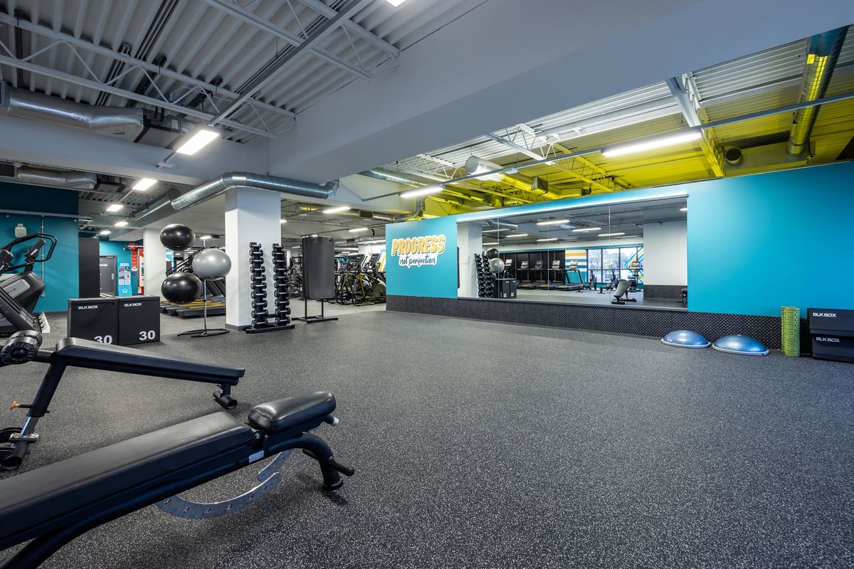 PureGym Motherwell: Free weights, resistance machines, floor mats, and vibrant colour accents in a contemporary gym space.